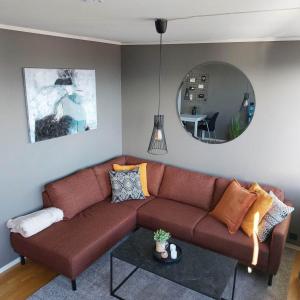 ein Wohnzimmer mit einem braunen Sofa und einem Spiegel in der Unterkunft Ferienwohnung für 2 Personen ca 35 m in Haugesund, Südnorwegen in Haugesund
