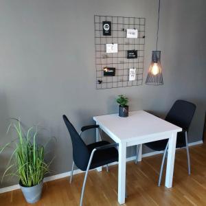 einem weißen Tisch mit zwei Stühlen und einer Topfpflanze in der Unterkunft Ferienwohnung für 2 Personen ca 35 m in Haugesund, Südnorwegen in Haugesund