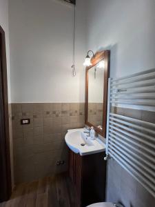 La salle de bains est pourvue d'un lavabo, d'un miroir et de toilettes. dans l'établissement Villa Arianna, à Cori