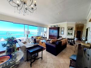 a living room filled with furniture and a large window at Stylish Penthouse with 180 degree Ocean Views! in Cape Town