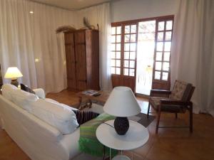 una sala de estar con un sofá blanco y una lámpara sobre una mesa. en Dachterrassen-Loft mit Bergblick, en Sencelles