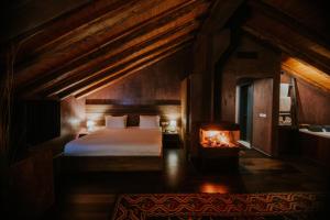 Dim's Hotel & Restaurant في كورتشي: غرفة نوم بسرير ومدفأة