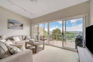 a living room with a couch and a large window at Water View Home - Minutes To Town in Batemans Bay
