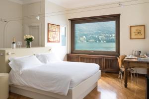 een slaapkamer met een bed, een bureau en een raam bij Villa Noseda in Moltrasio