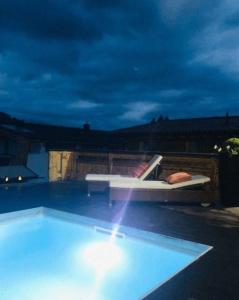 - une piscine la nuit avec un lit et une piscine dans l'établissement Ferienhaus in Seefeld In Tirol mit Großer Terrasse, à Seefeld in Tirol