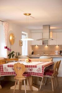 une cuisine avec une table et des chaises ainsi qu'une cuisine avec un plateau/bouilloire dans l'établissement Ferienhaus in Seefeld In Tirol mit Großer Terrasse, à Seefeld in Tirol