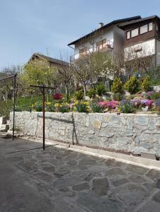 une maison avec un mur en pierre et un jardin dans l'établissement Apartman AMY, à Jajce