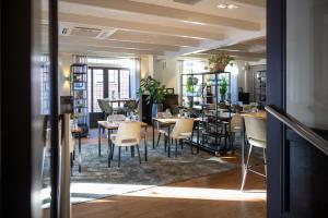 Hotel Aalsmeer في آلسمير: مطعم فيه طاولات وكراسي في الغرفة