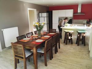 une femme debout dans une cuisine avec une table en bois dans l'établissement Schön renoviertes Ferienhaus für acht Personen in idyllischer Lage, mit Terrasse und Garten, à Ellezelles