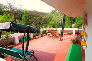 a patio with chairs and tables and an umbrella at Sunflower Skyline Pent House in Bangalore