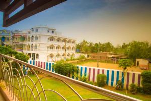 ein weißes Gebäude mit einem bunten Zaun davor in der Unterkunft Hotel Raj in Puri