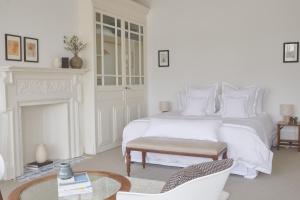 a white bedroom with a bed and a fireplace at River Arts Club in Maidenhead