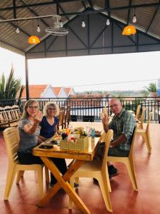 un grupo de personas sentadas en una mesa en Sunrise Dốc Lết en Ninh Hai