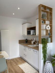 a kitchen with white cabinets and a sink at Le Refuge du Lac in Chaumousey +50 photos