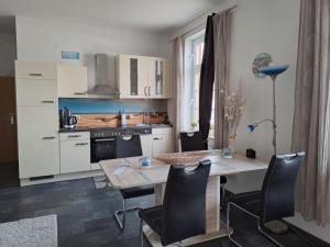 - une cuisine avec une table et des chaises dans la chambre dans l'établissement Apartment Krabbe, à Fedderwardersiel
