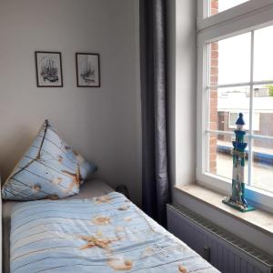 - une chambre avec un lit à côté d'une fenêtre dans l'établissement Apartment Krabbe, à Fedderwardersiel