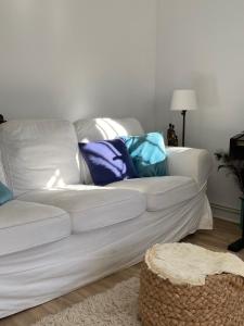 un sofá blanco con almohadas coloridas en la sala de estar en Ferienhaus für 3 Personen 1 Kind ca 86 qm in La Franca, Costa Verde Spanien Küste von Asturien, en La Franca