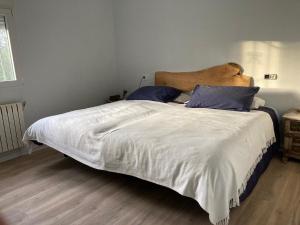 1 dormitorio con 1 cama grande con sábanas blancas y almohadas azules en Ferienhaus für 3 Personen 1 Kind ca 86 qm in La Franca, Costa Verde Spanien Küste von Asturien, en La Franca
