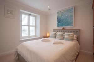 a bedroom with a white bed with two towels on it at Chy An Gweal Farm Cottage in Carbis Bay