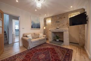 a living room with a couch and a fireplace at Chy An Gweal Farm Cottage in Carbis Bay