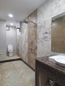 a bathroom with a sink and a shower and a toilet at MAYUR HOTEL in Dimāpur