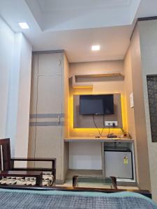 um quarto com uma televisão na parede e uma cama em MAYUR HOTEL em Dimāpur