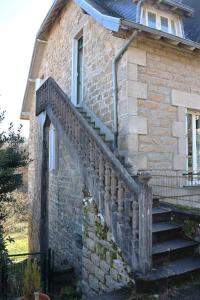 un bâtiment en briques avec un escalier sur son côté dans l'établissement La cigalienne, à Treignac
