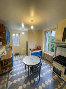 eine Küche mit einem Tisch in der Mitte eines Zimmers in der Unterkunft La cigalienne in Treignac
