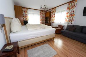 uma sala de estar com uma cama e um sofá em Geräumige Wohnung in Gemeinde Flattach mit Großer Terrasse em Flattach