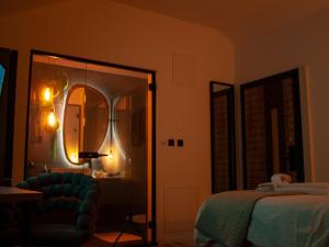 ein Schlafzimmer mit einem Bett, einem Spiegel und einem Stuhl in der Unterkunft NOVA LUXURY DESIGN in Zagreb