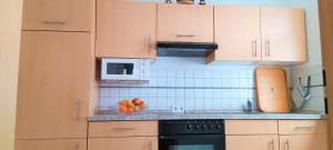 een keuken met houten kasten en fruit op de toonbank bij Waldblick Nordhorn in Nordhorn