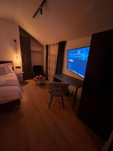 NOVA LUXURY DESIGN في زغرب: غرفة فندقية بسرير وتلفزيون بشاشة مسطحة
