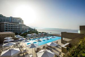 a swimming pool with umbrellas and a resort at Atlantica Nissaki Beach - Adults Only in Gimari