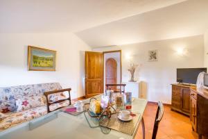 ein Wohnzimmer mit einem Tisch und einem Sofa in der Unterkunft Magnolia ad Antico Casale '700 in Umbertide