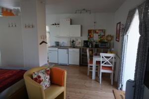 uma cozinha e sala de estar com mesa e cadeiras em Ferienwohnung Maurer em Mücheln