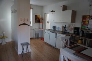 uma cozinha com armários brancos e piso em madeira em Ferienwohnung Maurer em Mücheln