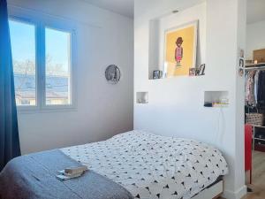 a bedroom with a bed and a window at Maison familiale 140m² avec jardin in Saint-Ouen