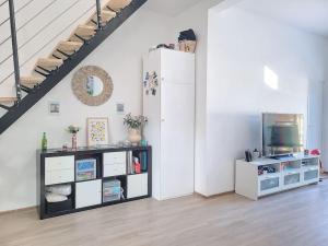 a living room with a white refrigerator and a tv at Maison familiale 140m² avec jardin in Saint-Ouen
