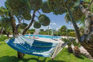 a hammock in a tree next to a pool at Ferienhaus mit Privatpool für 4 Personen 1 Kind ca 70 qm in San Vito dei Normanni, Adriaküste Italien Ostküste von Apulien in San Vito dei Normanni