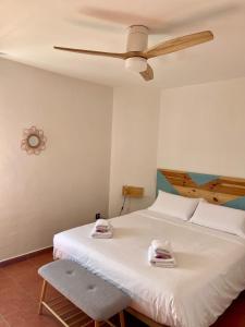 een slaapkamer met een bed en een plafondventilator bij Primera línea de playa Radazul in Radazul