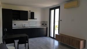 una cucina con armadi neri e tavolo con sedie di Black and White B&B Urgnano a Urgnano Altre 11 foto