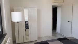 Habitación blanca con espejo y lámpara en Black and White B&B Urgnano, en Urgnano