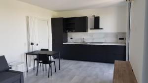 una cucina con armadi neri, tavolo e sedie di Black and White B&B Urgnano a Urgnano