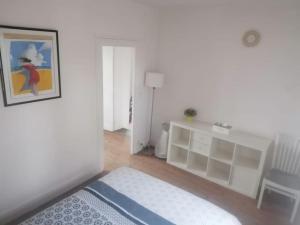 een slaapkamer met een bed, een bureau en een foto bij Maison entre ville et campagne in Amilly