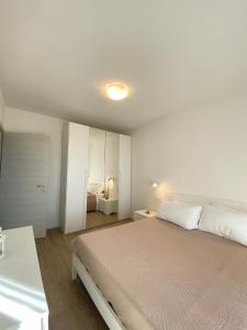 een witte slaapkamer met een bed en een witte kast bij Ferienwohnung für 2 Personen 2 Kinder ca 60 qm in Lazise, Gardasee Ostufer Gardasee in Lazise
