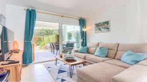 a living room with a couch and a table at Bellresguard Garden Flat C in Port de Pollensa