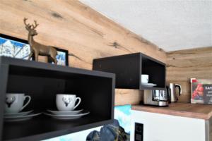 a room with a tv and two cups on a shelf at Ferienwohnung-Allgaeu-Pfronten -Inkl KönigsCard in Pfronten