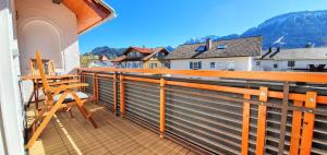 a balcony with a wooden railing and a table and chairs at Ferienwohnung-Allgaeu-Pfronten -Inkl KönigsCard in Pfronten