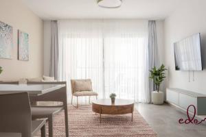 ein Wohnzimmer mit einem Sofa und einem Tisch in einem Zimmer in der Unterkunft דירת משפחתית 2 חדרי שינה במיקום מרכזי - By Edom in Eilat