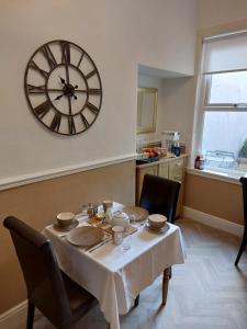a dining room with a table and a large clock on the wall at Storrbeck Guest House in Whitby +17 photos